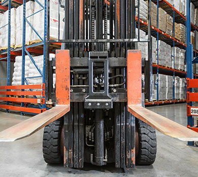 Forklift carriage bumper used to prevent pallet damage in warehouse